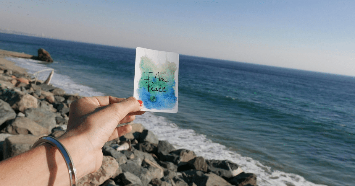 image-1 - California Mental Health Positive Psychology: Hand holding 'I Am Peace' card on beach. Mental wellness and peace affirmation for mindfulness.