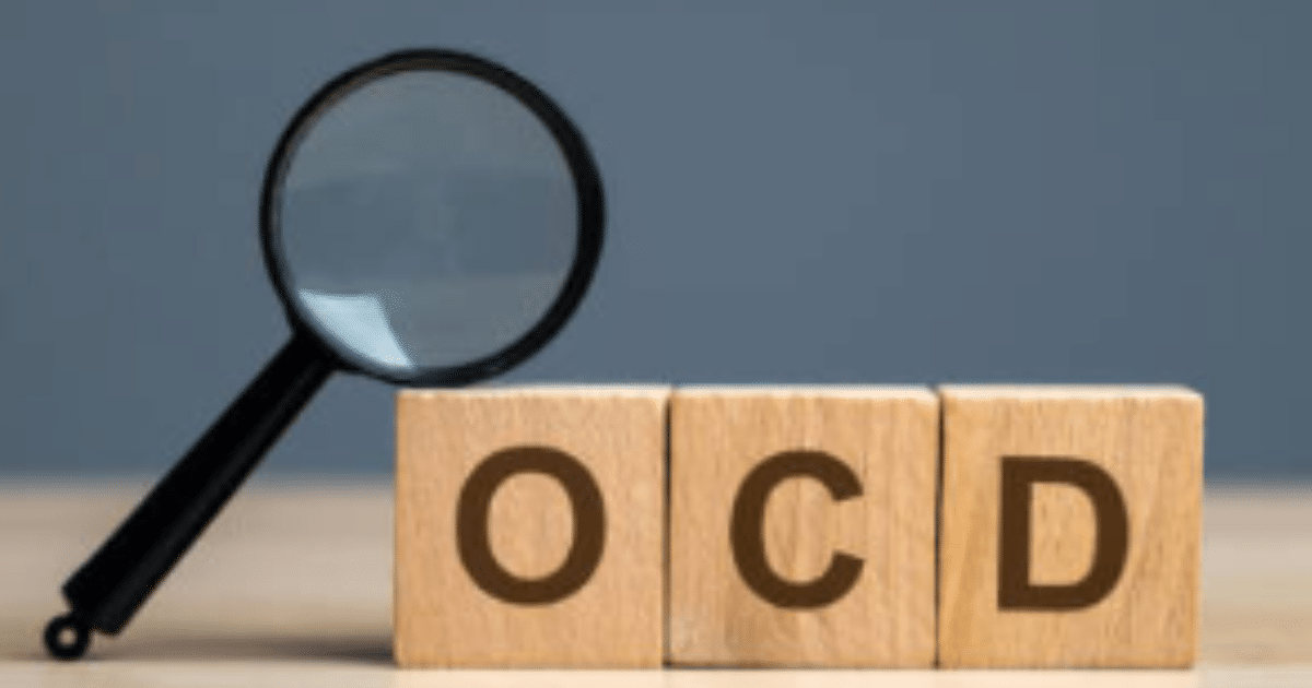 AD_4nXeLrJgSivoC2oQOyBtYWrF7MakkPihDl5I-bxpx_iGEz0vAY_mJrmQHn6PosaWyuM1BY2NvV1Sqrnoh-MW9nMcoKnAmhP2VjUgLgDg8QfPvjTFGqEzH89nACtrx6EUrHLtf_W4O7A - California Mental Health OCD concept: Magnifying glass over wooden blocks spelling "OCD", illustrating Obsessive-Compulsive Disorder and mental health.