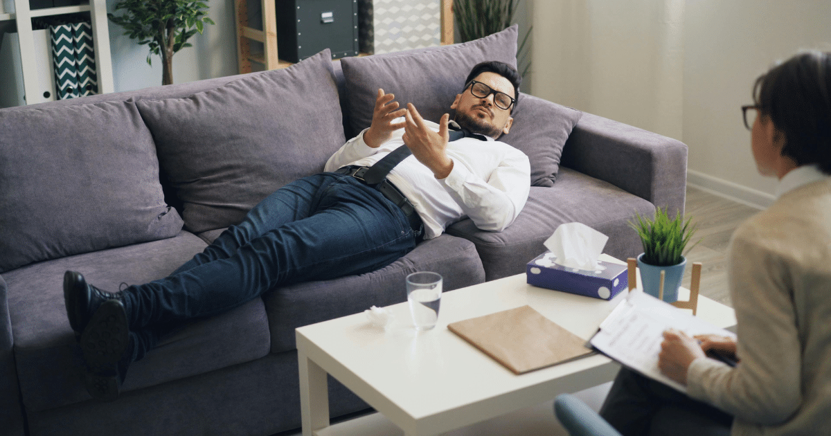 AD_4nXdHd5TVOAZNUIbCIJ8Mjc1e6Fek2IhO447dTdSD4xWPTlgnMTKvyNCC6oc9EkV8cJf4sonT9_Dfb7JkqZEHFqBbvg6LLZh8Xt6EcyhcwlhWd7R-QqJZKLenyo9NQDdxU-rptRlYuw - California Mental Health Man on couch talking to therapist about schizophrenia. Mental health counseling session for global population with mental illness.