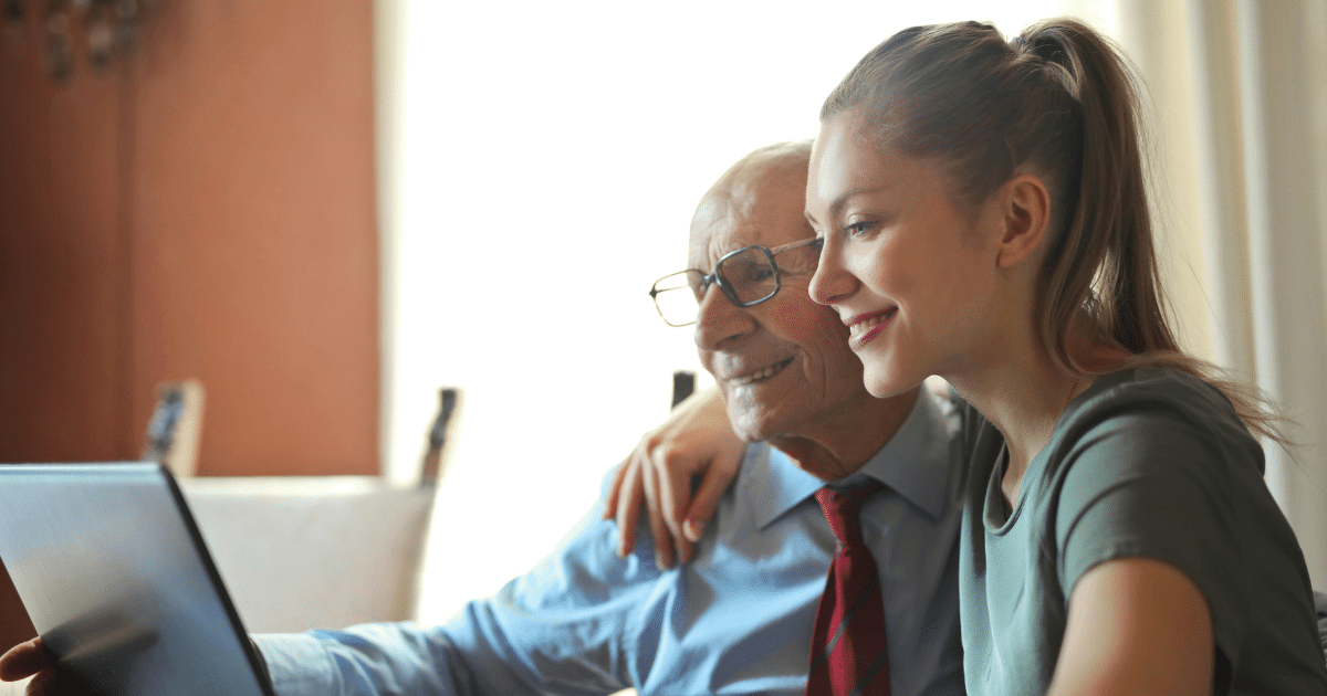 AD_4nXe10fVqYcMdlRmea4yG4MQ-mlIKpX5Klk0Zxz9ZWRwUI0cowneRNjnVqnNco5PikbpfKi9AqL4BeG3VxhE5BrO0be2bM3_STyLZbXy7gTlz1ATdOUM6qOs0Y6dN7VP-BH6C8pTp - California Mental Health Senior man with caregiver using a laptop, supporting mental instability with compassionate care strategies.