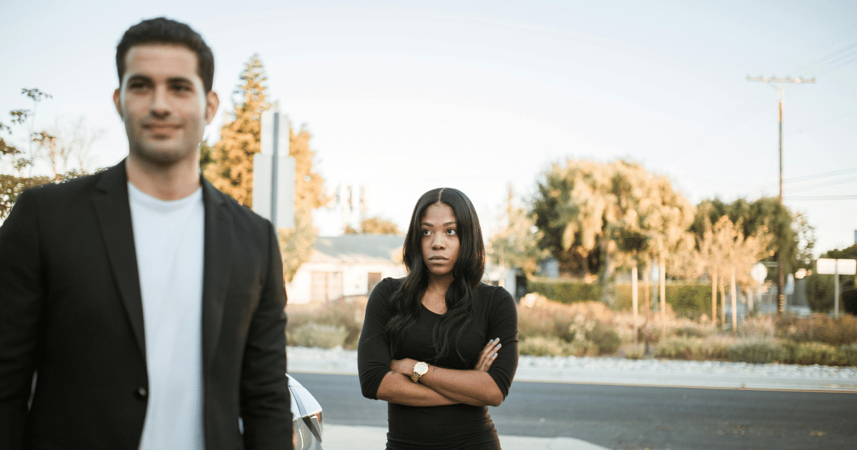 AD_4nXc6v6mOwhk2lF3rDis7mbfG_FzHH6pPdStlC9esho-JXj1geq5rzuOiIJdPeZxTGboS645NLU3AL2vscPfFdMr4UPGvTtKum5DTL0JNKrCxgdr2Df9IYCfQz3jaYXnSpqPaHem9 - California Mental Health Jealousy in Relationships: A woman with arms crossed looks suspiciously as a man smiles in the background.