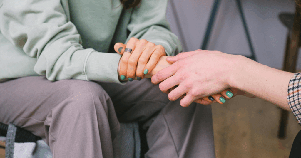 image - California Mental Health Support for Anxiety: Two people holding hands. Mental health and anxiety relief concept. Showing empathy and care.