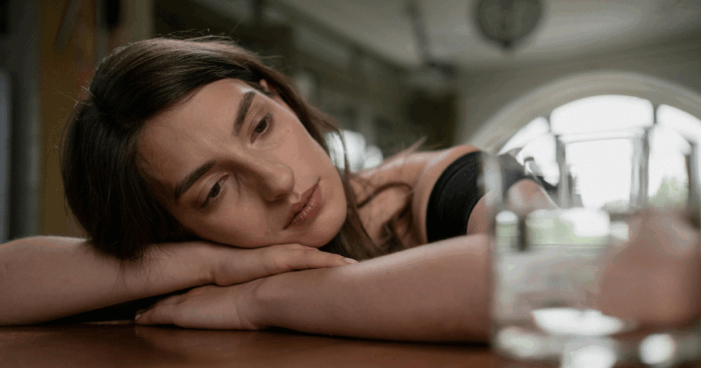 image - California Mental Health Sad woman resting head on arms. Concept of transvestic disorder and mental health. Focus on emotional expression and well-being.