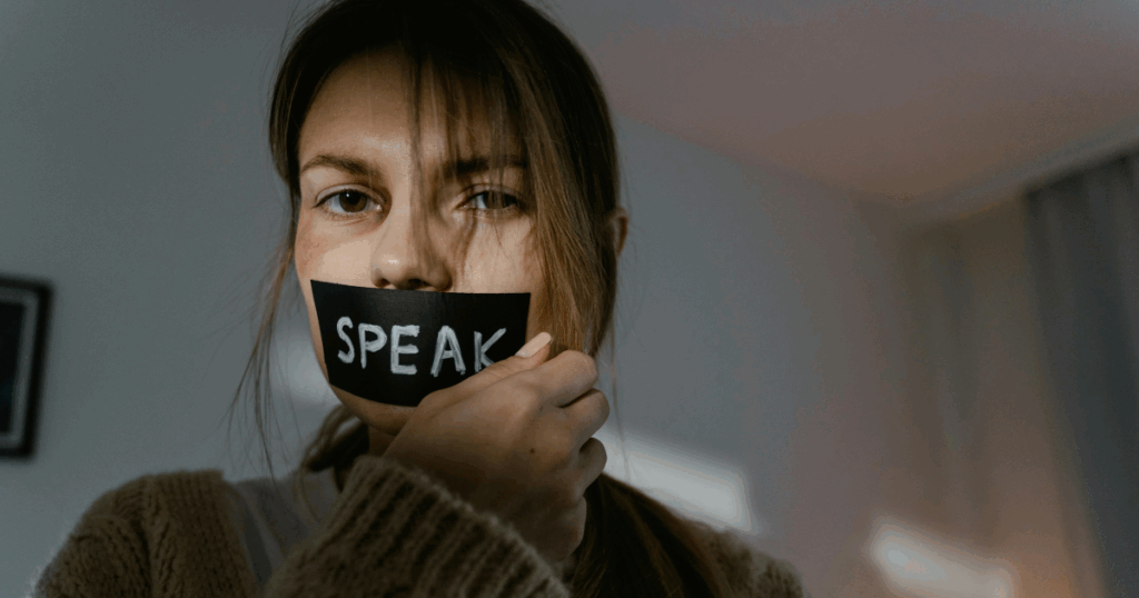 image - California Mental Health Woman with 'SPEAK' tape on mouth, psychological dimensions of expression, Exhibitionistic Disorder concept, mental health awareness.