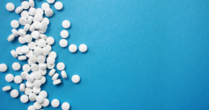 - California Mental Health White round pills scattered across a bright blue background on the left side of the image.