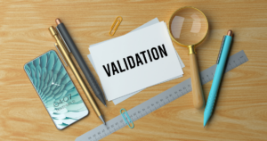 - California Mental Health Card labeled VALIDATION on a wooden desk with a magnifying glass, ruler, pens, a paper clip, and a smartphone nearby.
