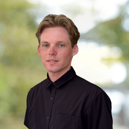 Chase Mcquowa portrait. Headshot of professional man with blond hair wearing a collared shirt.