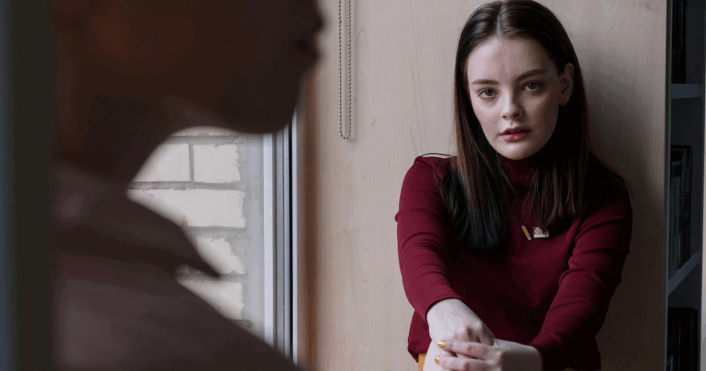 Woman in red turtleneck looking concerned, reflecting anxiety or a panic attack. Mental health awareness and support concept.