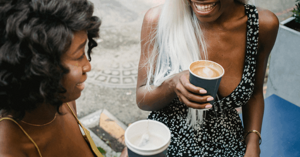Two smiling women with coffee. Social anxiety, entomophobia, and mental health concepts for support and overcoming fear.