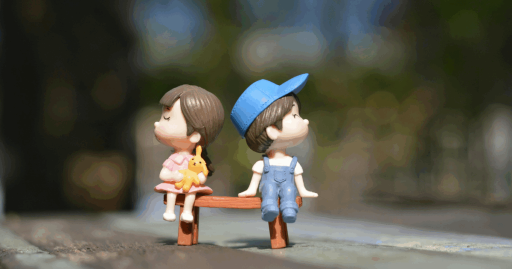 Figurines of a boy and a girl sitting on a bench, symbolizing relationship challenges and potential arousal disorder issues.