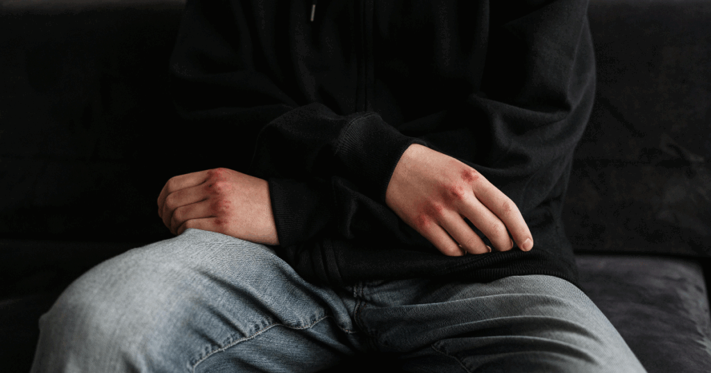 image - California Mental Health Person in hoodie and jeans sitting, representing trauma and stressor disorders therapeutic approaches.